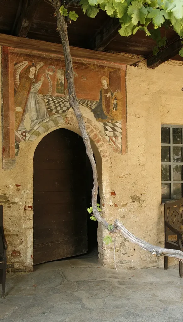 Affresco dell’Annunciazione sotto un portico storico del Castello di Bagnolo Piemonte