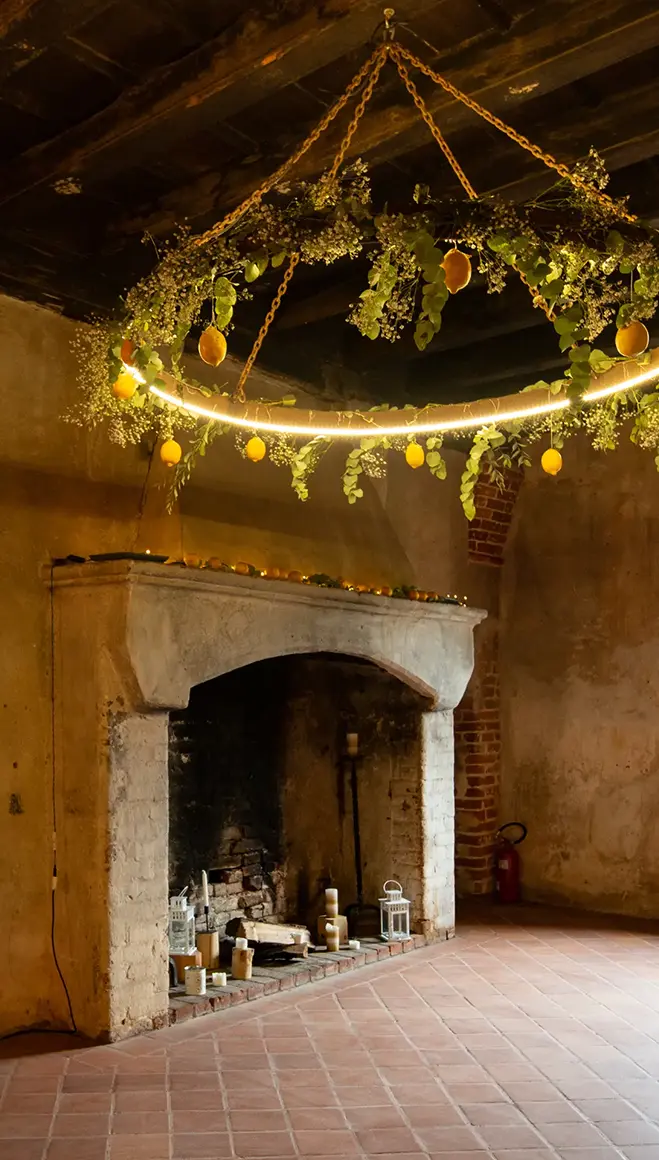 Camino in pietra con architrave sagomato in una sala del Castello medievale con tavoli rotondi apparecchiati e soffitto in legno.