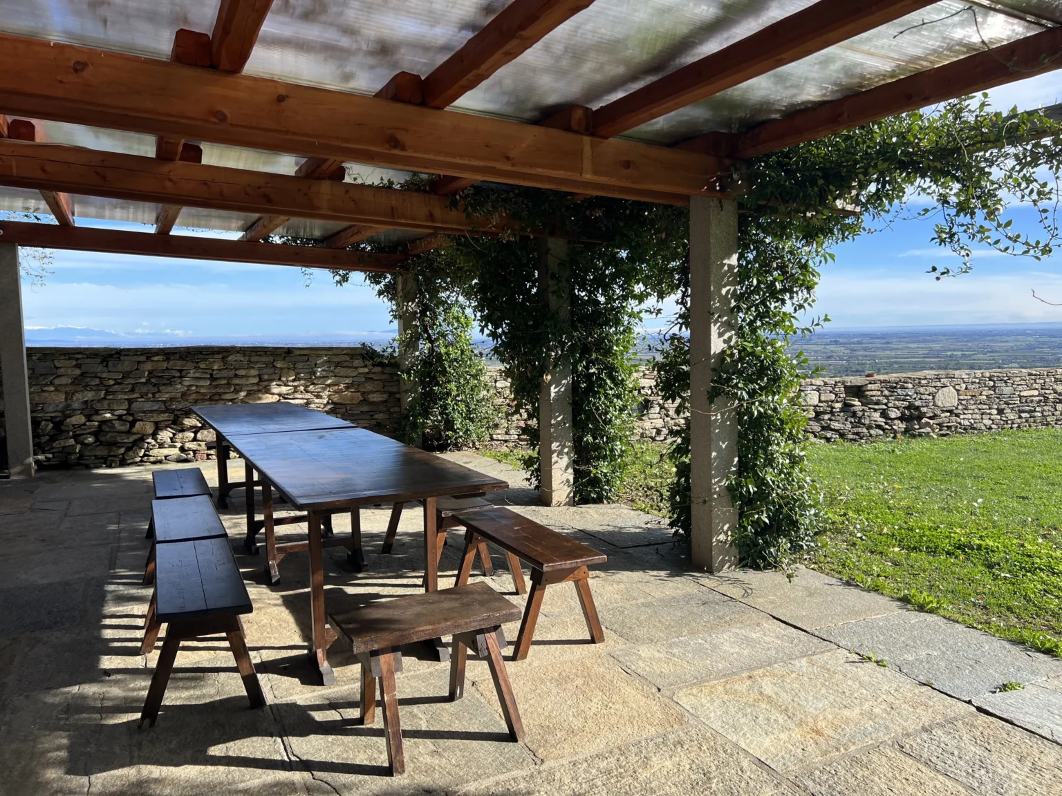 Pergolato con tavolo in legno affacciato sul parco e sul panorama della pianura presso il Castello di Bagnolo