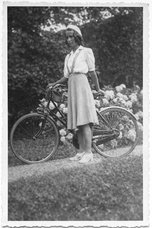 Ragazza con bicicletta in piedi su un sentiero nel parco