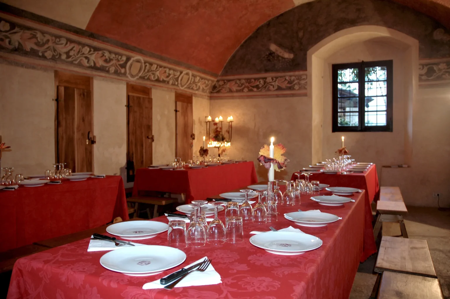 Sala storica del Castello medievale con soffitto decorato e tavoli apparecchiati per cena o evento